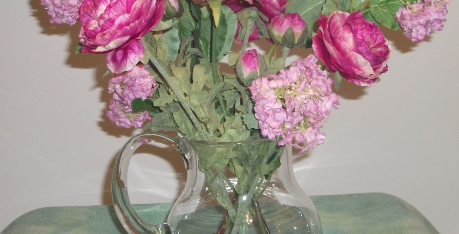 Z119 Large glass jug containing vintage pink ranunculus and vibernum