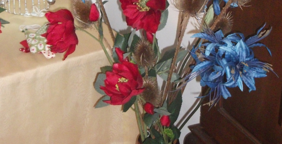 Z098 Tall copper vase containing blue nerines, red helibores and teasels