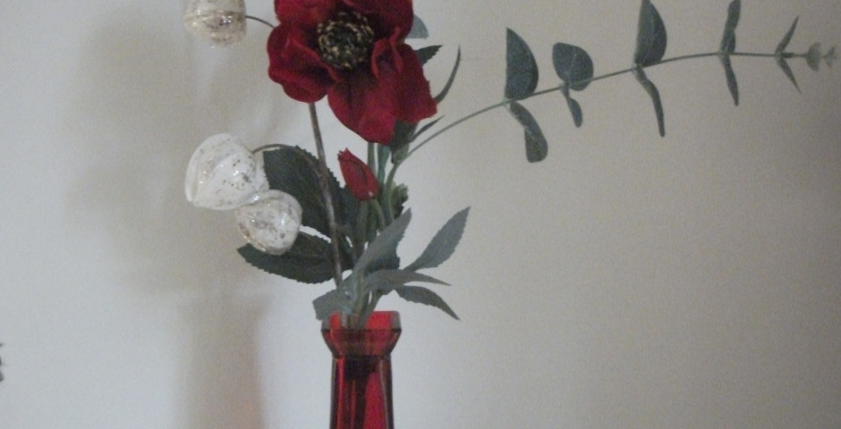 Z114 Tall Christmas arrangement in a red vase with red helibore, eucalyptus and silver Chinese lanterns